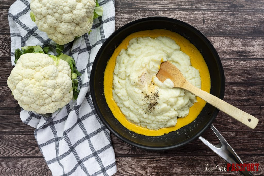 mashed steamed cauliflower being added to cheese, cream and garlic butter